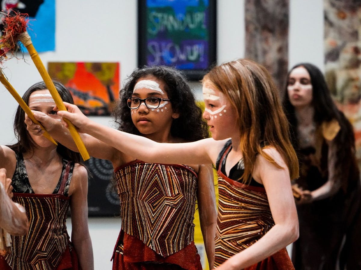 Children dressed in traditional First Nations costume and makeup perform a dance