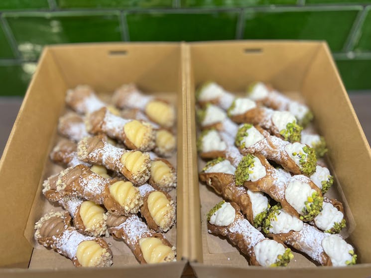 Take home packs of daily made cannoli filled with pastry cream and almond or ricotta and pistachio.