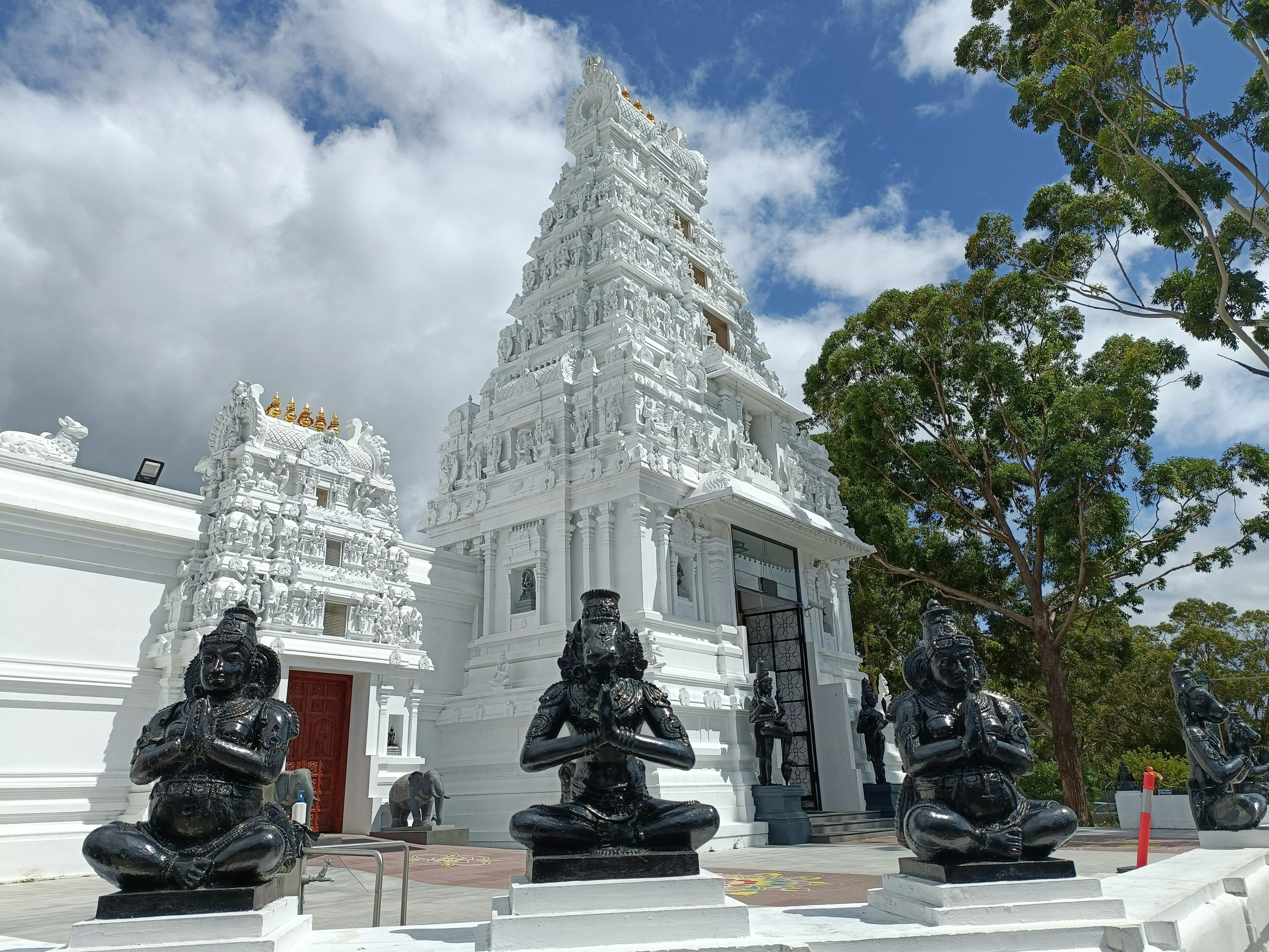 White Hindi temple with marble staues in foreground