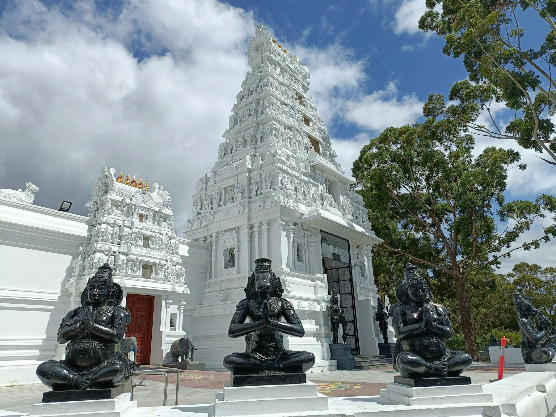 White Hindi temple with marble staues in foreground