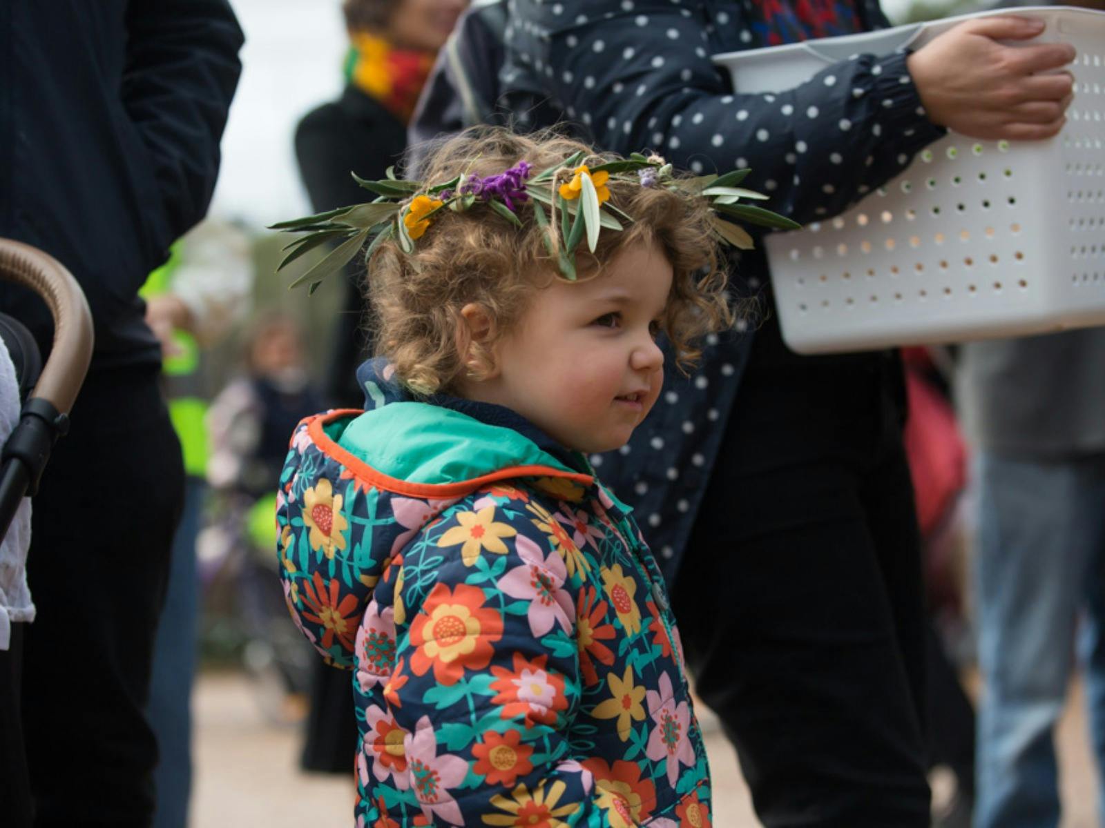 A toddler wearing a flower crown enjoys the festival.