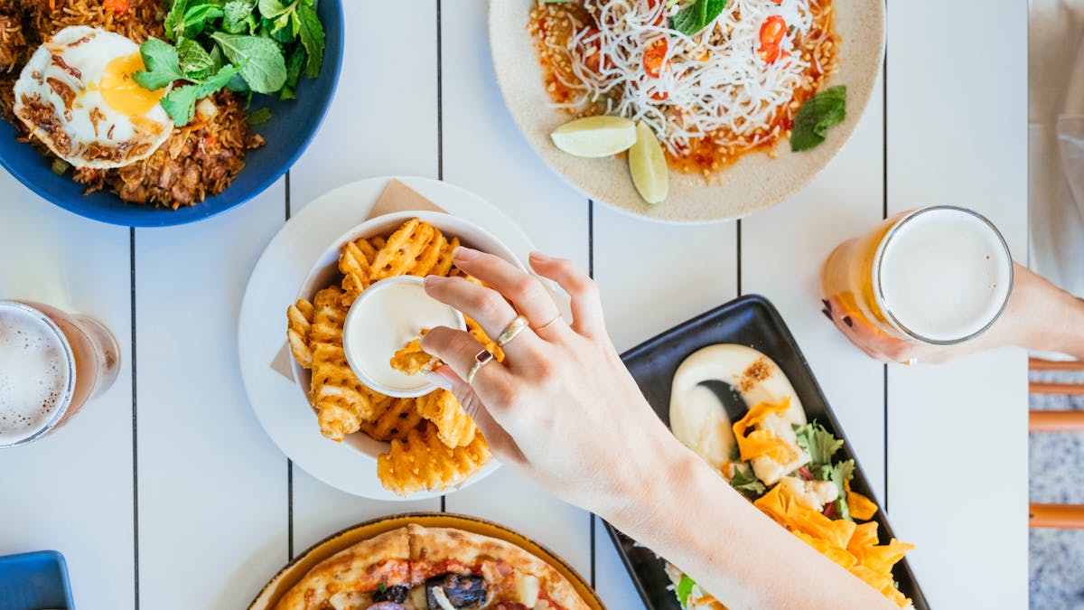 Looking down on a table with plates of food and drinks