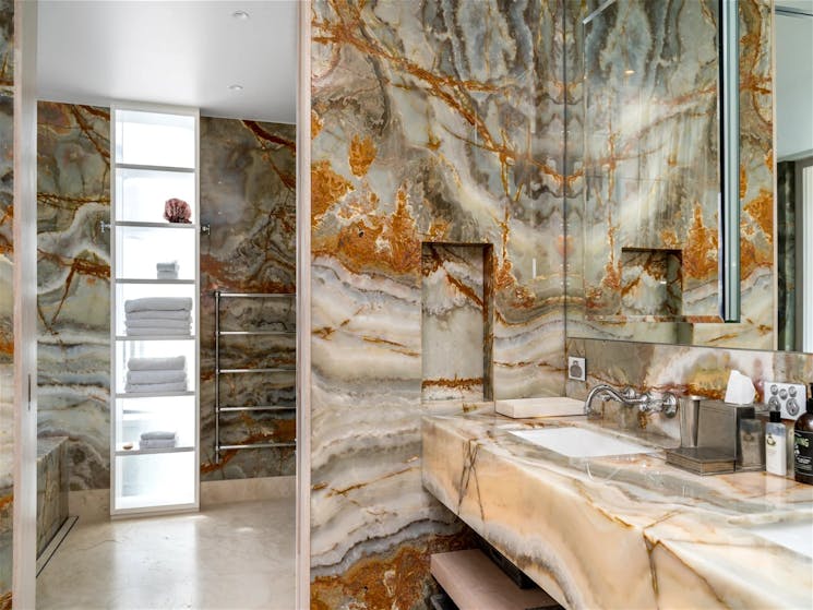 Elegant marble bathroom with a marble-topped vanity and marble accent wall