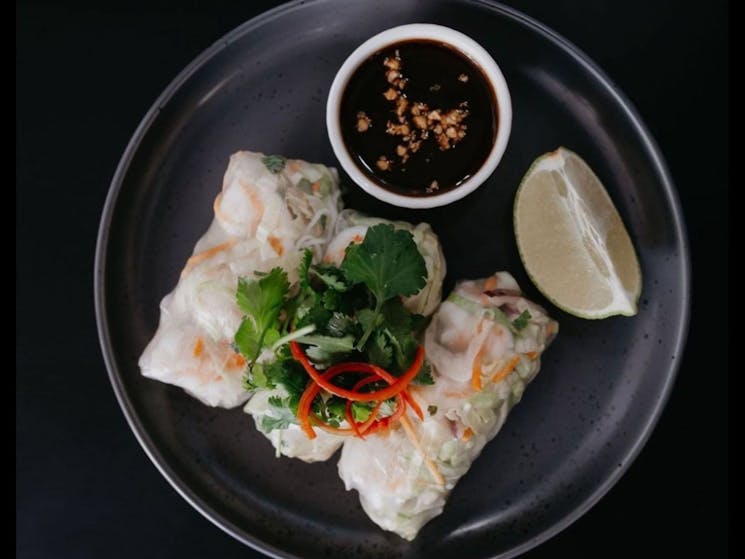 Rice paper rolls on a plate with dipping sauce