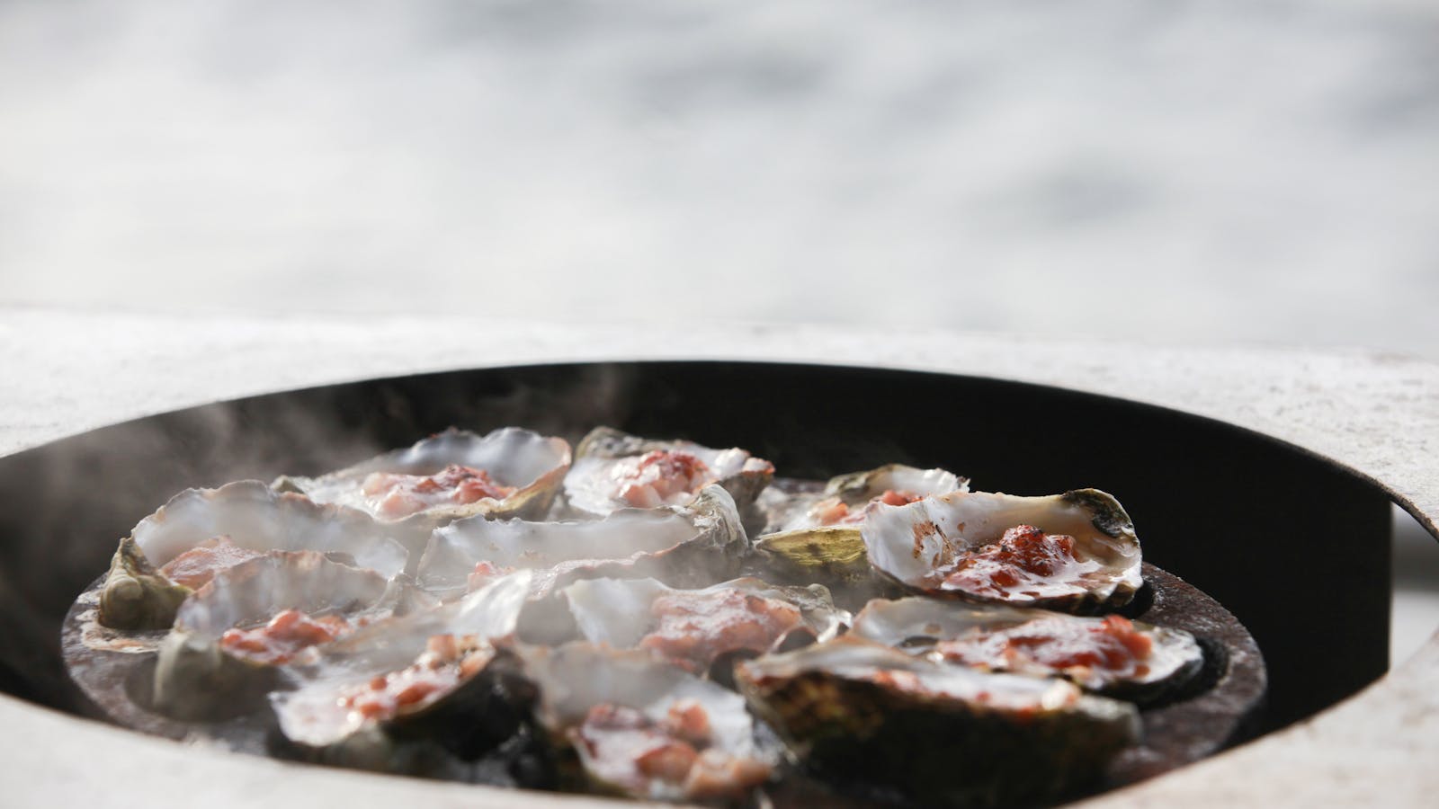 Fresh Kilpatrick oysters being cooked outdoors
