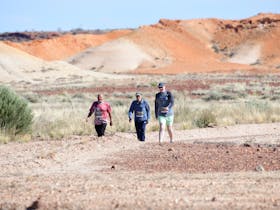 three walkers walking through coloured hill area of Kanku-Breakaways