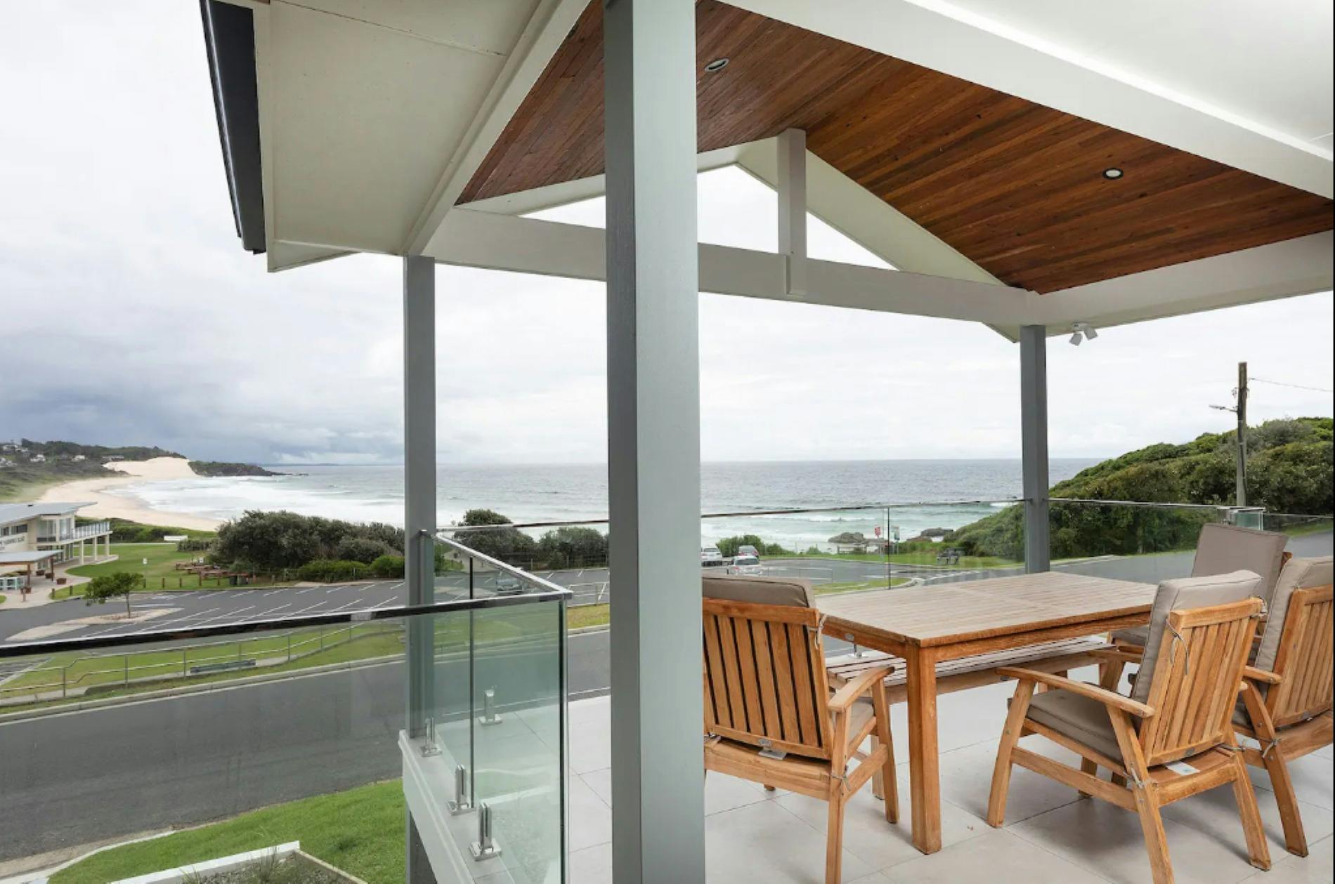 Balcony with outdoor dining setting and beach views