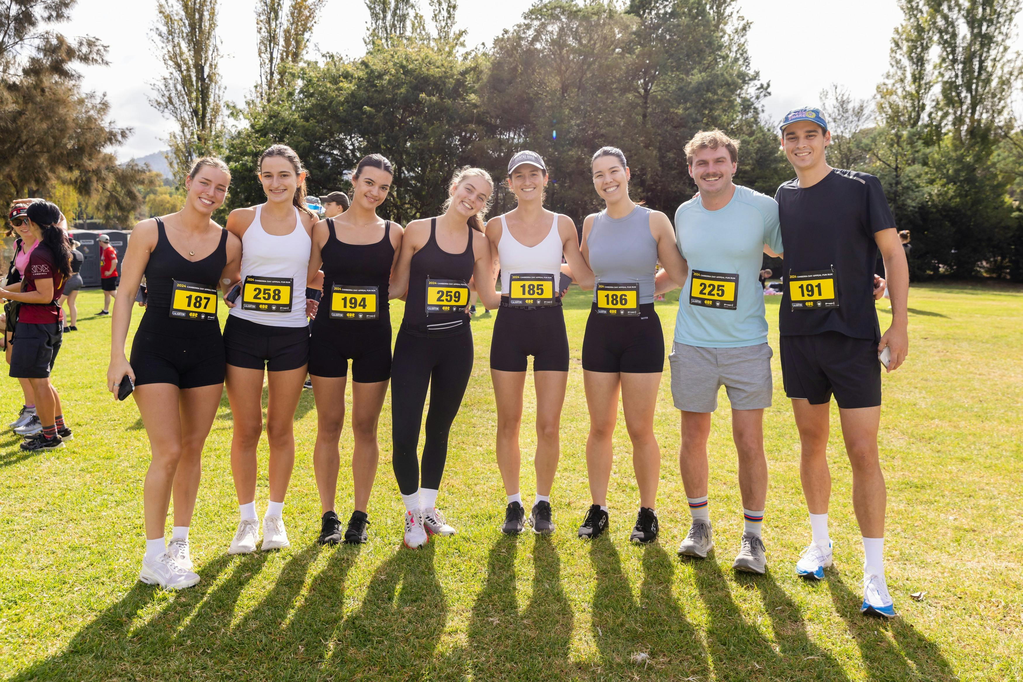 Group of people smiling to the camera, prior to participating in the fun run