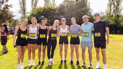 Group of people smiling to the camera, prior to participating in the fun run