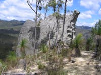 Large rock in foreground with hills in distance.