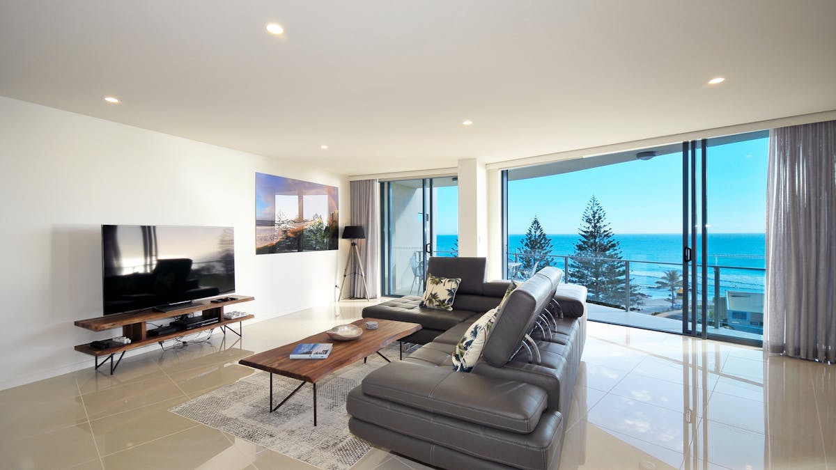 Contemporary lounge with high-gloss neutral tiles, brown leather sofa, and breathtaking ocean views Contemporary lounge with high-gloss neutral tiles, brown leather sofa, and breathtaking ocean views