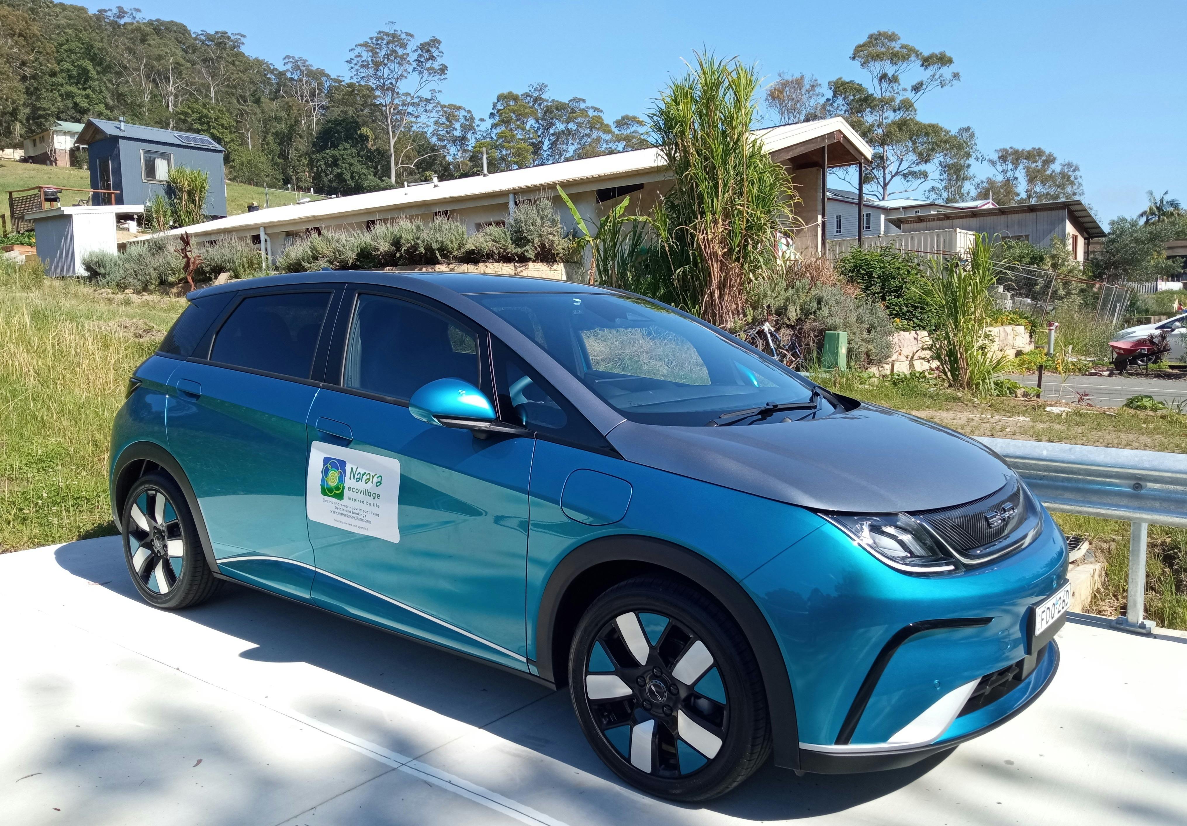 A blue electric car with car-share signs