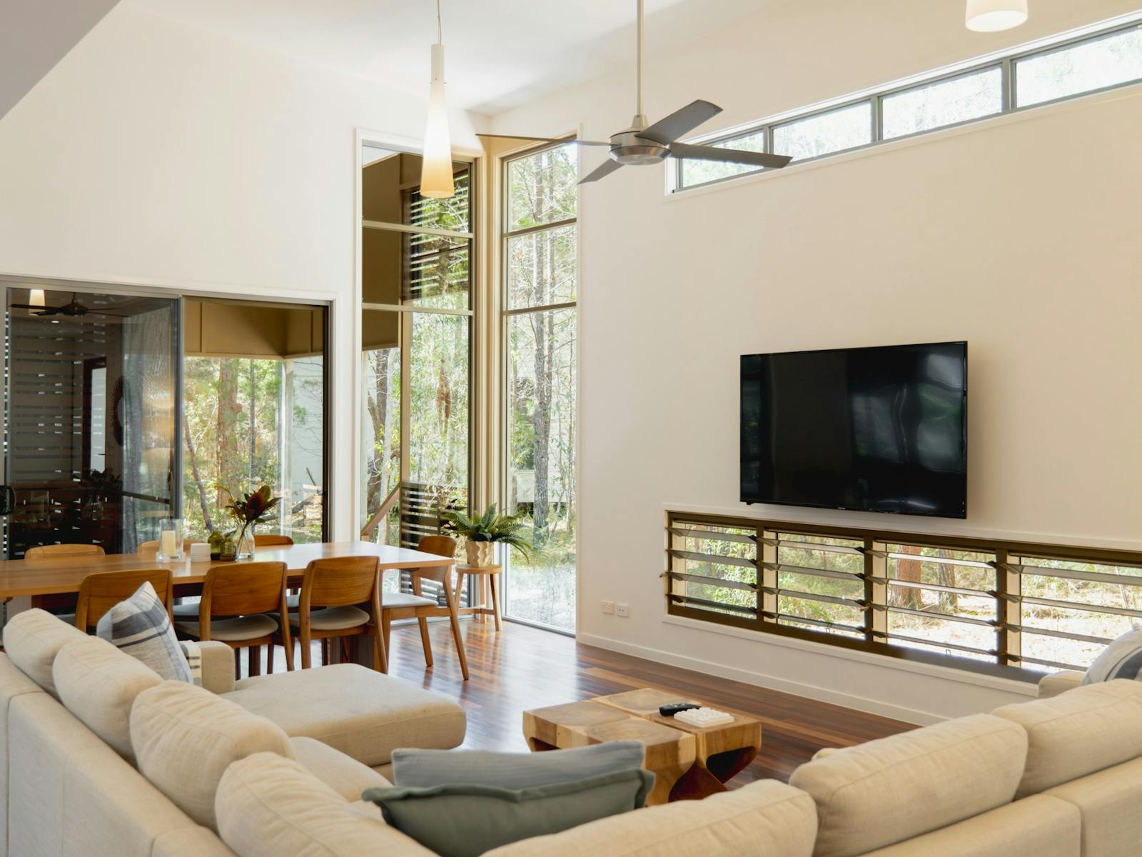 Open living area featuring a large couch, dining space, and expansive windows Open living area featuring a large couch, dining space, and expansive windows