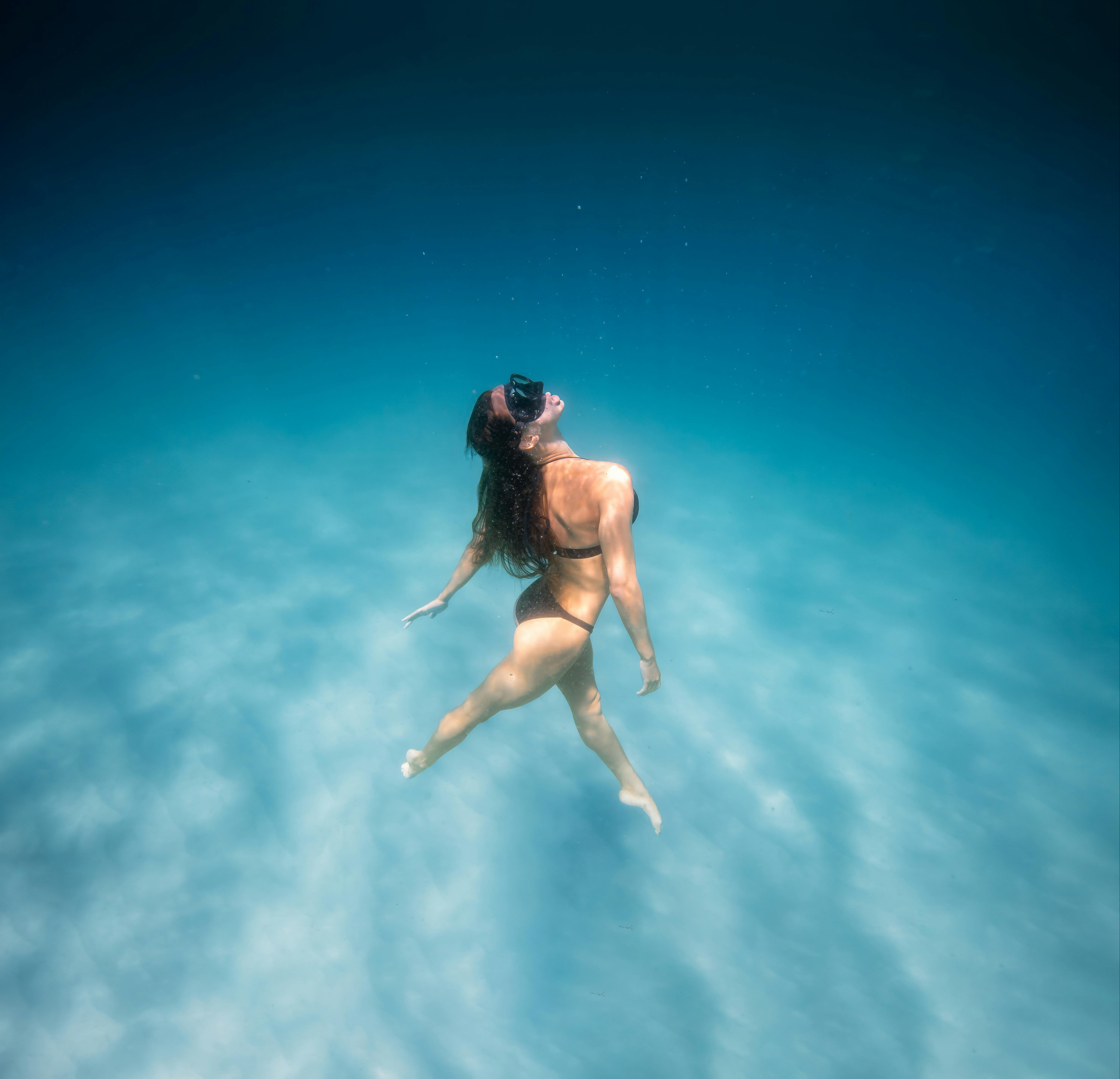 海面まで滑空する女性水泳選手