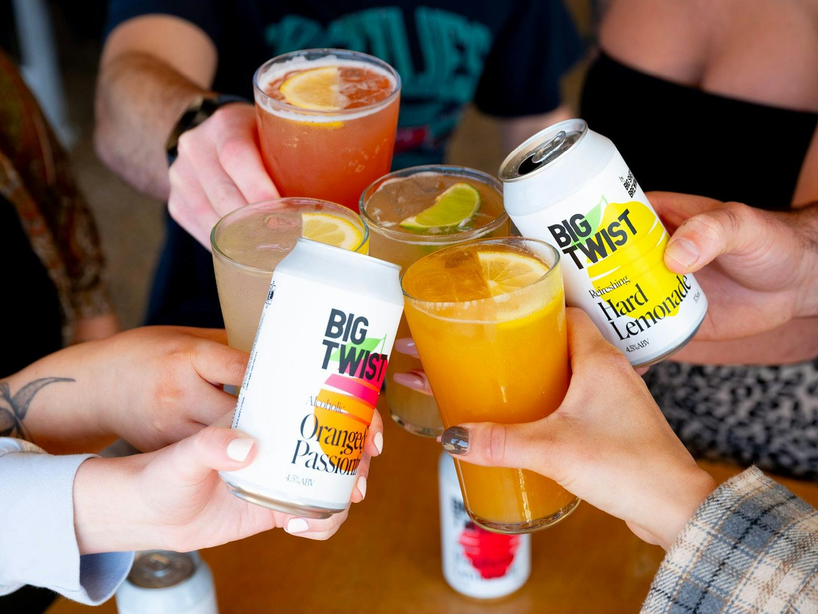 Hands with cans and glasses cheersing