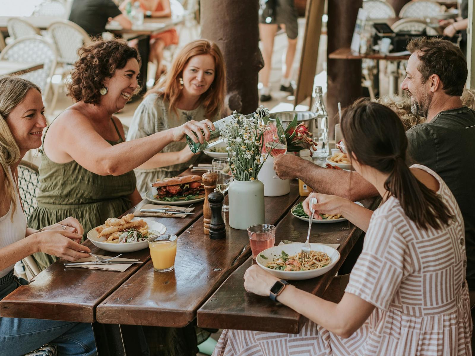 Audley Cafe에서 5명의 친구들이 식사를 함께하며 웃고 있습니다.