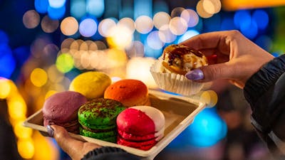 Set of 6 colourful macarons with Christmas lights in the background