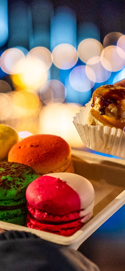 Set of 6 colourful macarons with Christmas lights in the background