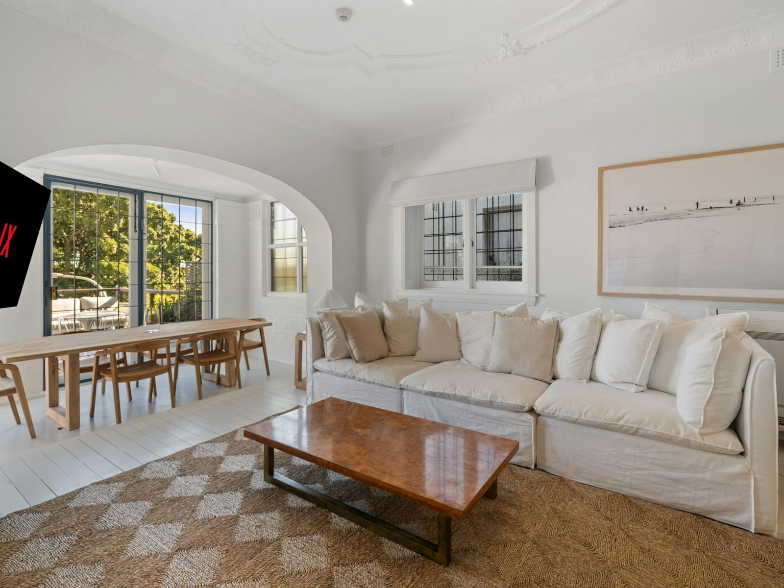 Living room with cozy sofa and dining area with outdoor balcony access.