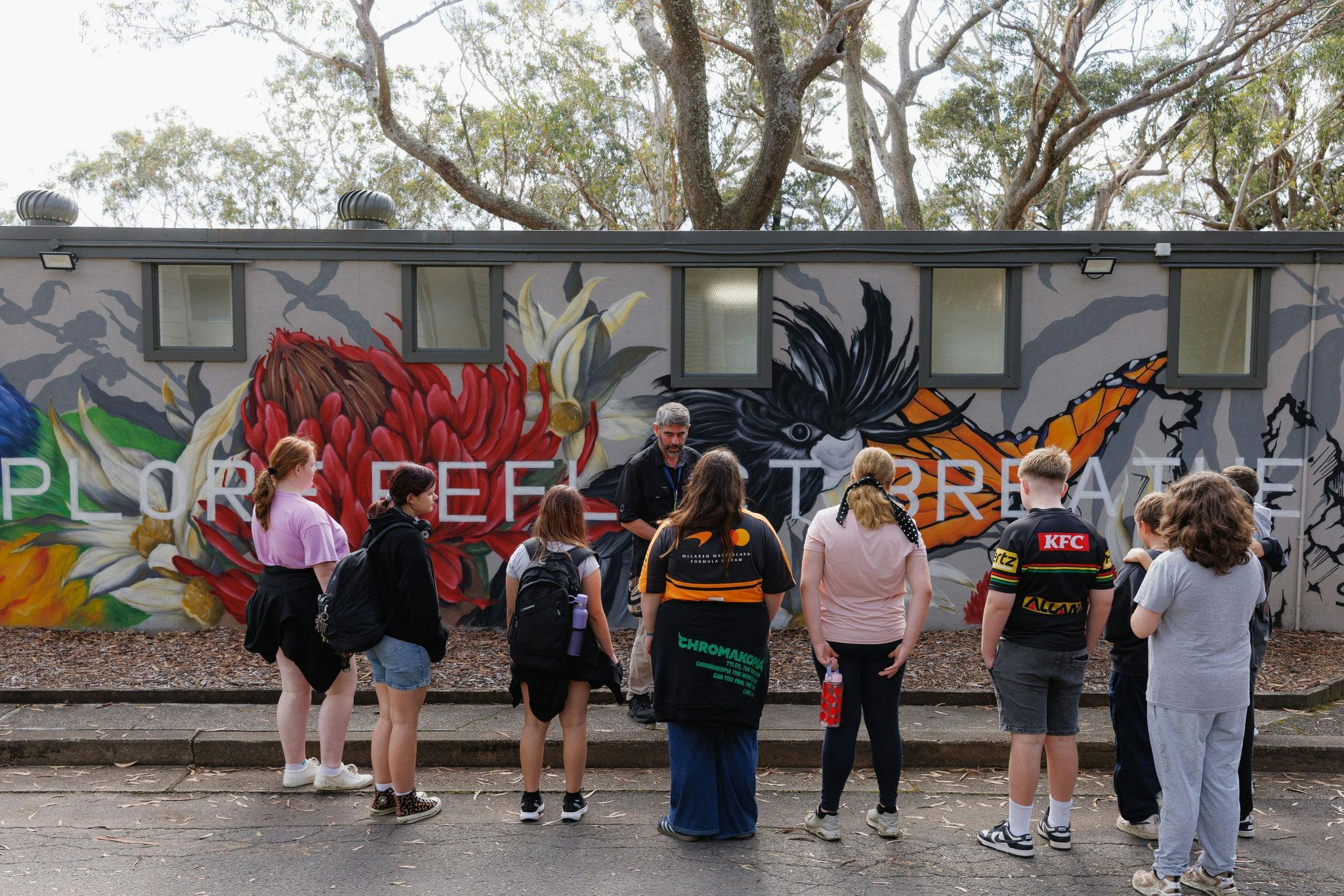Group briefing in front of the StayKCC mural wall