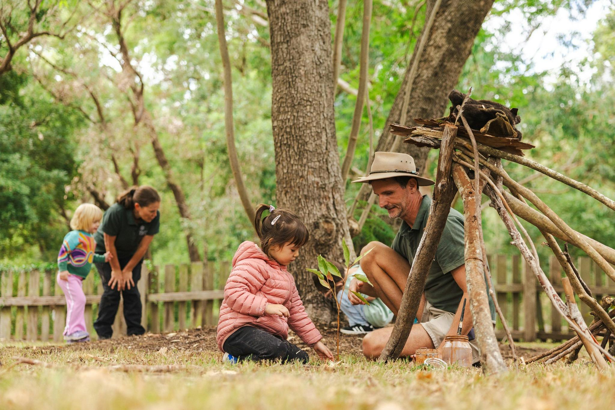 Children playing outdoors in nature with outdoor educators