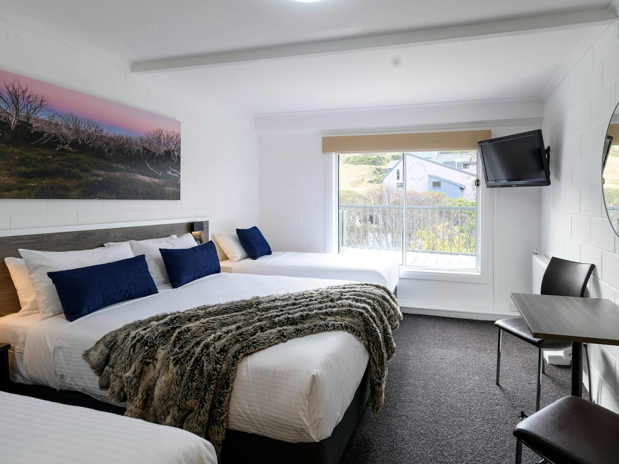 Room at Falls Creek Hotel showing bed and view from window
