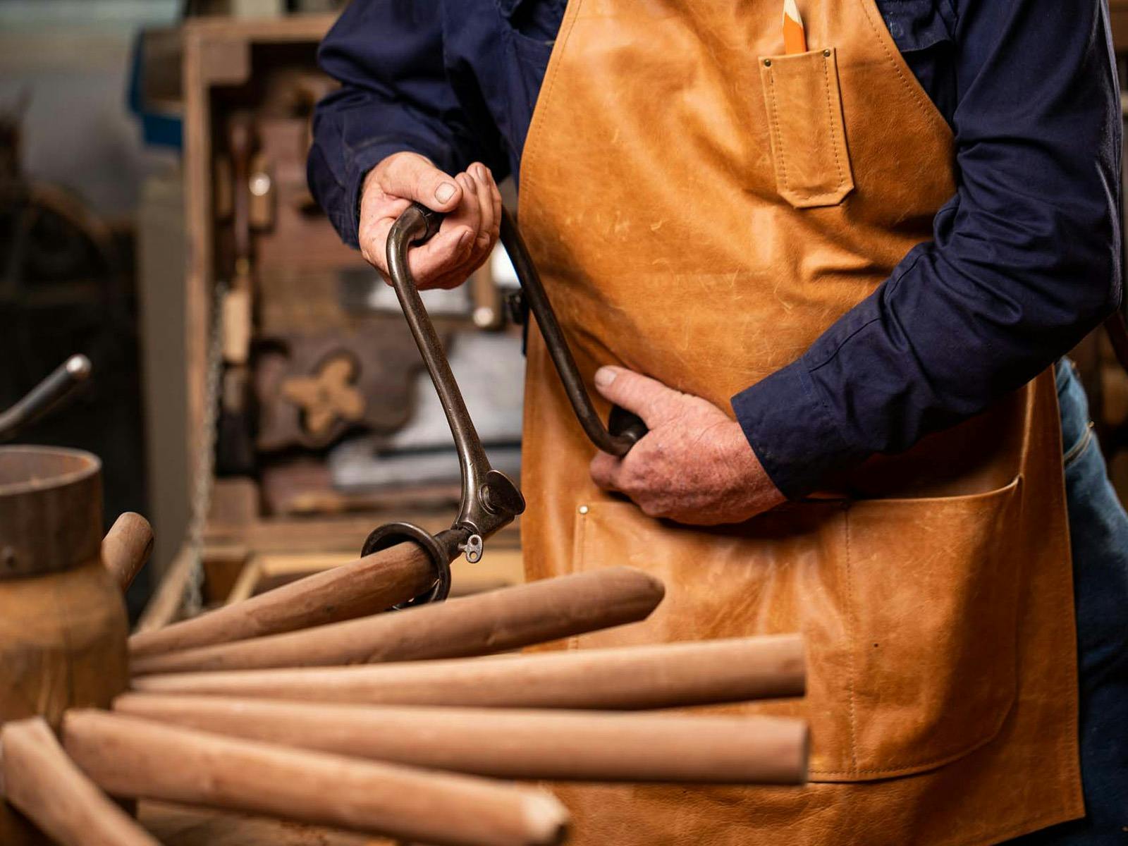 Man working on wooden wheel spokes with tool. Man working on wooden wheel spokes with tool.
