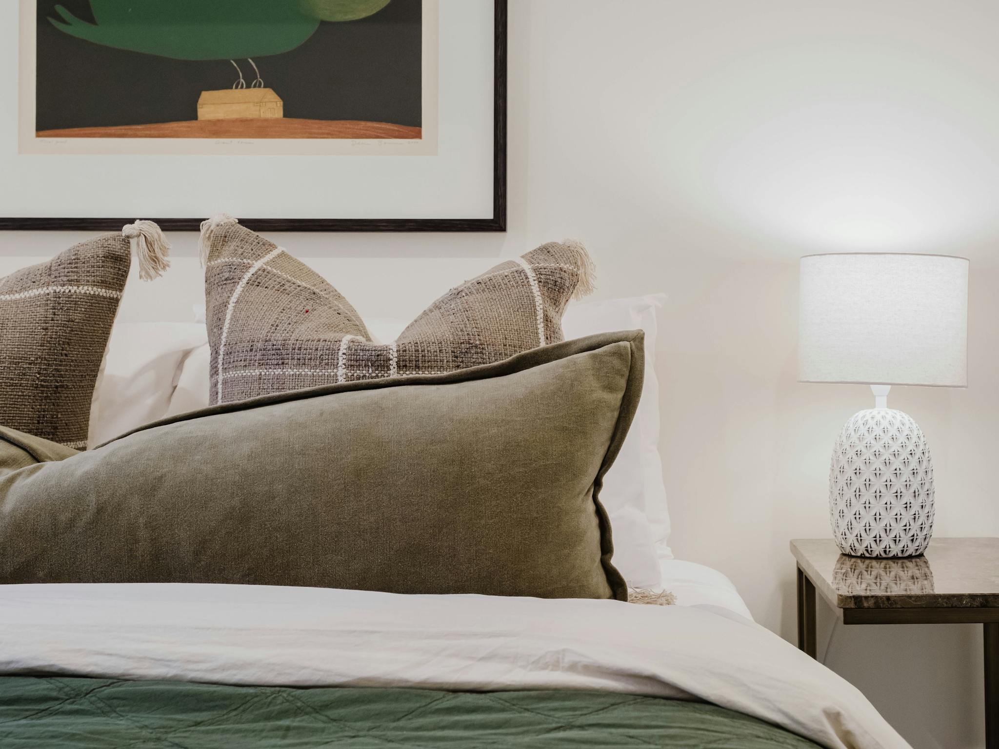 Bedroom with tableside lamp and painting
