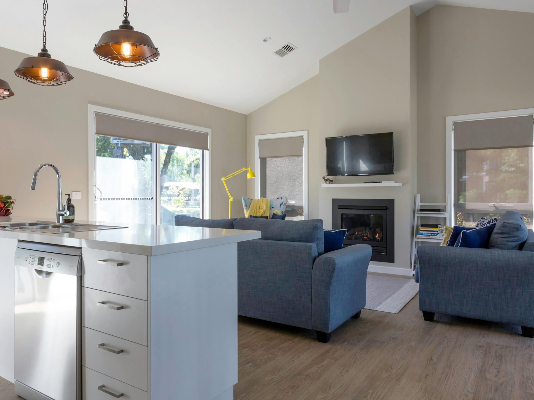 Summer Home's kitchen looking over lounge with gas fireplace