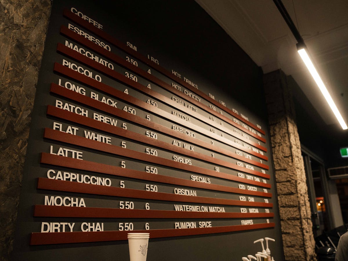 The menu board expanded, focusing on the hot drinks and specialty drinks side in large white font