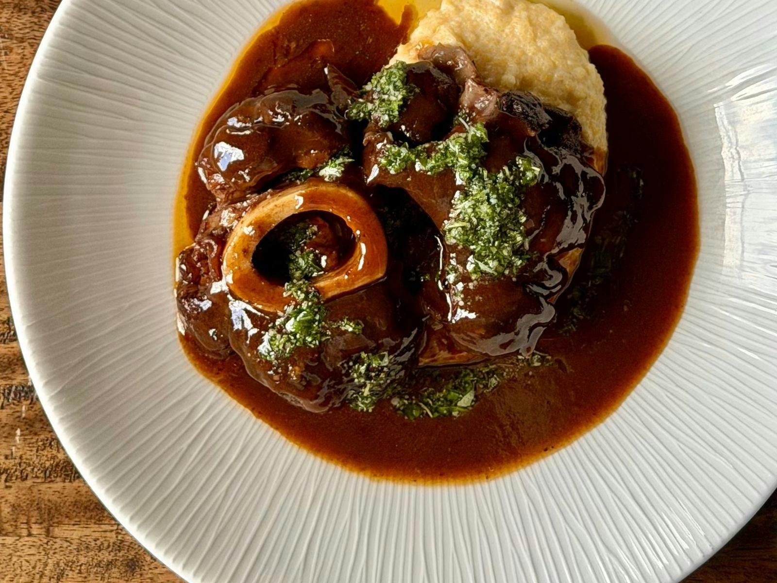 a picture of slow-cooked osso bucco with parmesan polenta and gremolata