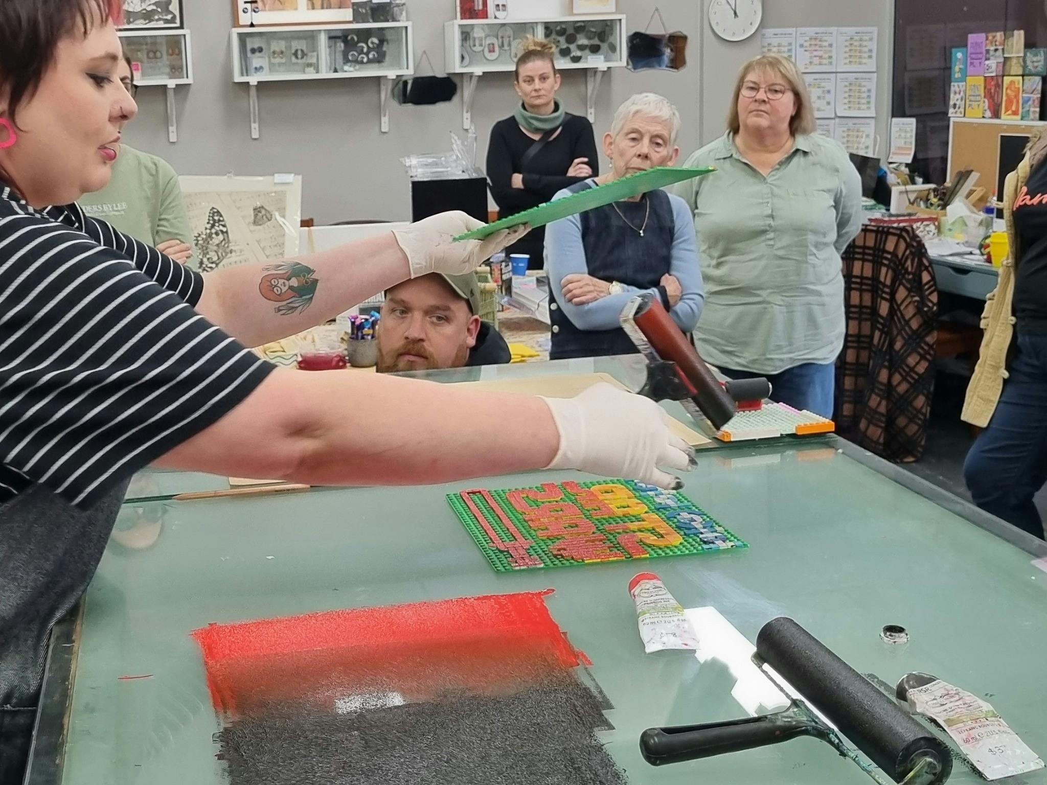 open day in printmaking studio, rolling ink onto Lego baseplate
