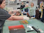 open day in printmaking studio, rolling ink onto Lego baseplate