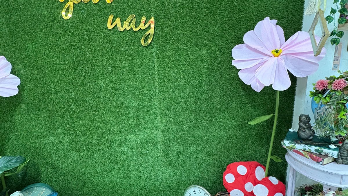 A beautiful grassy green wall with a sig n that says create your own way