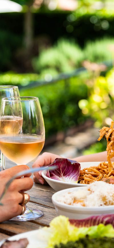 Table of food and wine set out before three guests.