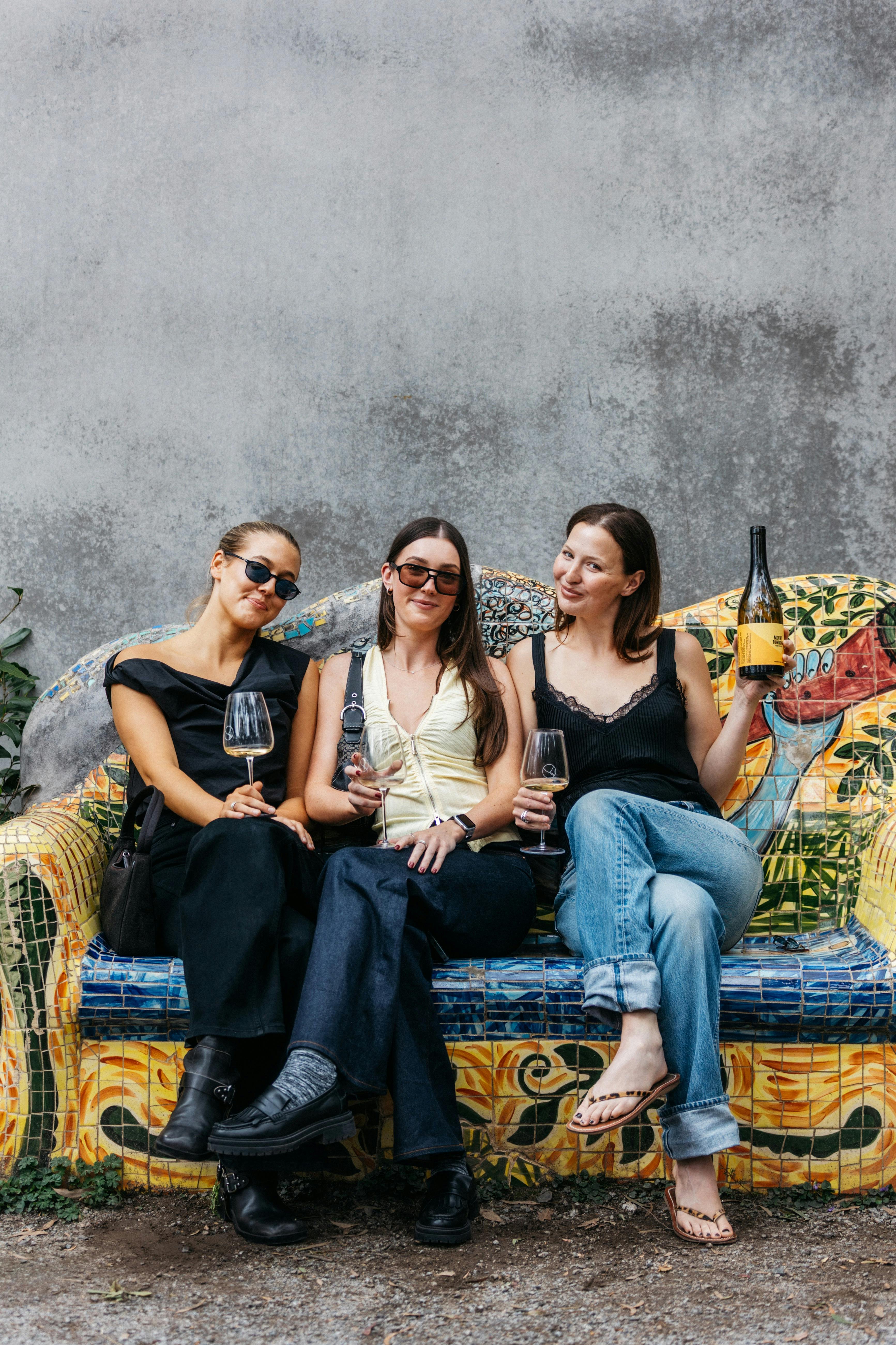 Three women enjoying a wine on a fun couch