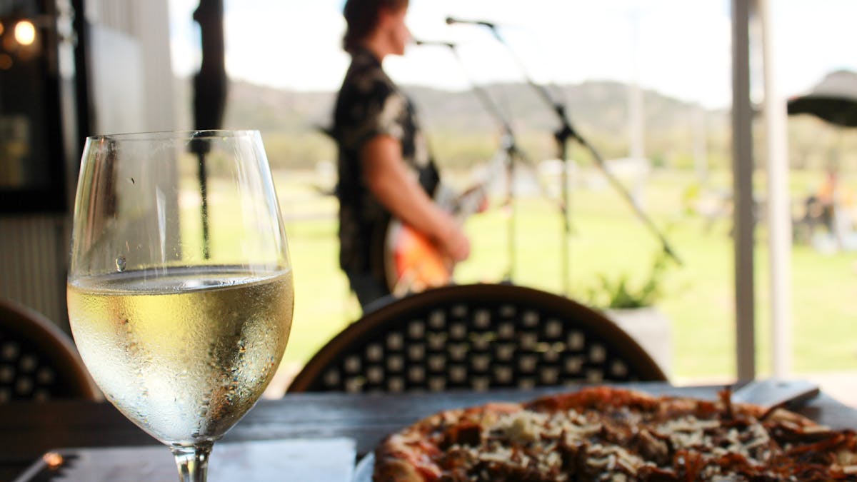 Pizza and wine overlooking musician at Balancing Heart Vineyard on the Granite Belt, South-East Q ld