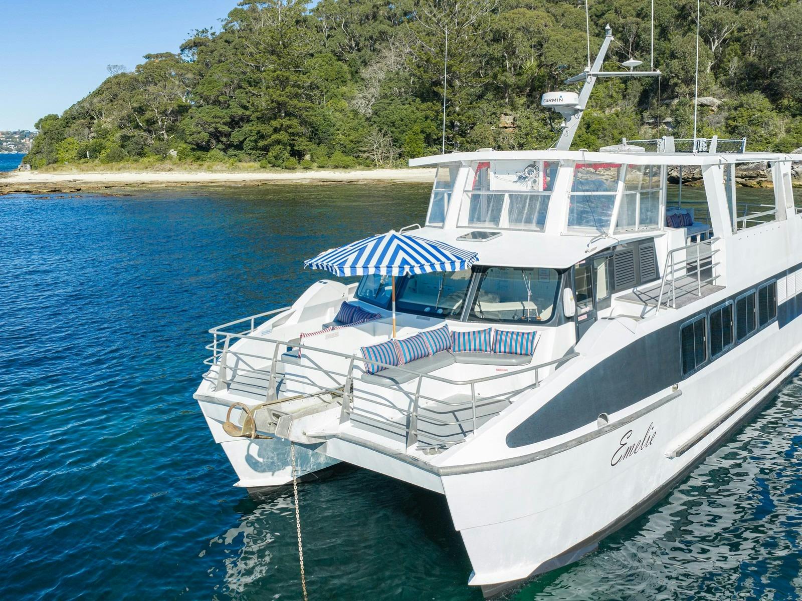 Front deck of Capri on Emelie with striped lounges and a blue and white umbrella