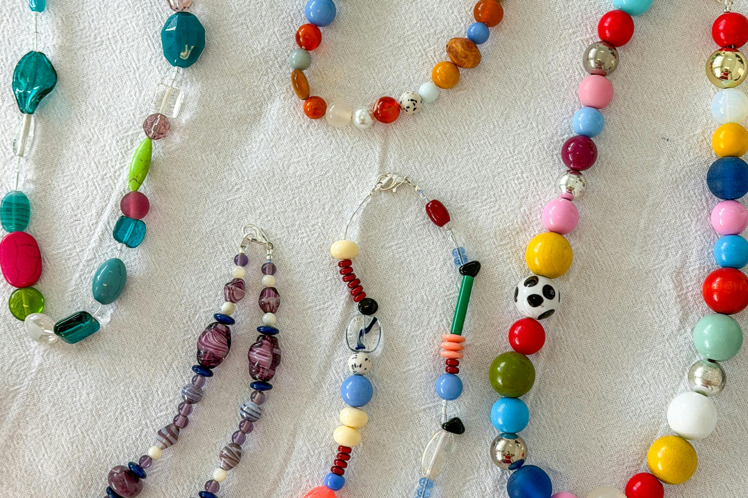 a white table covered in beaded necklaces