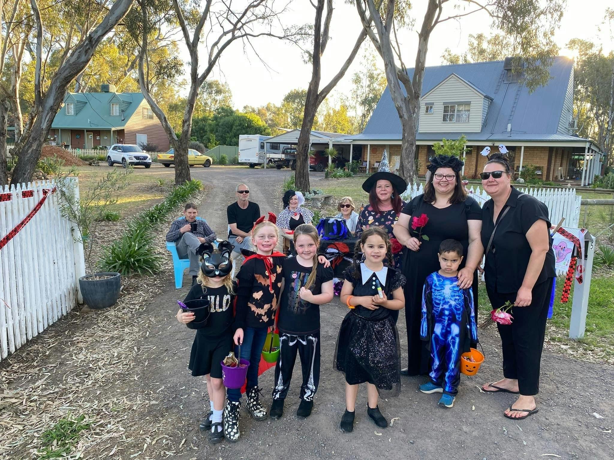 Group of kids and adults in costume trick-or-treating