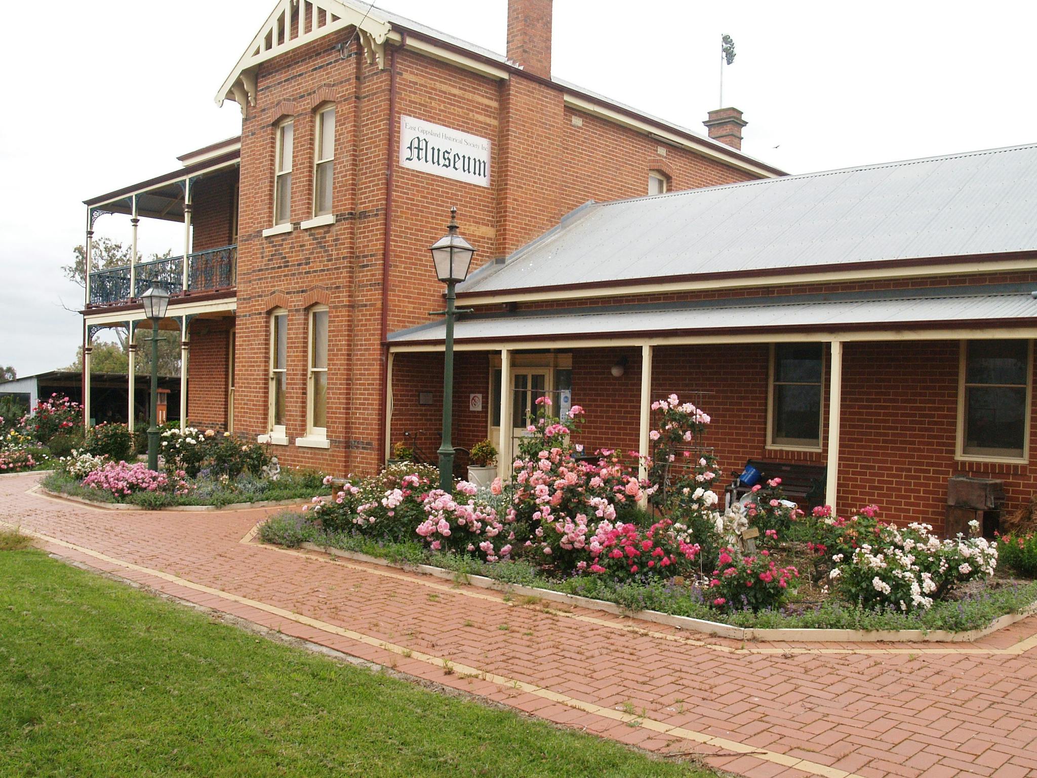 The museum with Australian bred rose gardens in front and  2 converted old style gas lights
