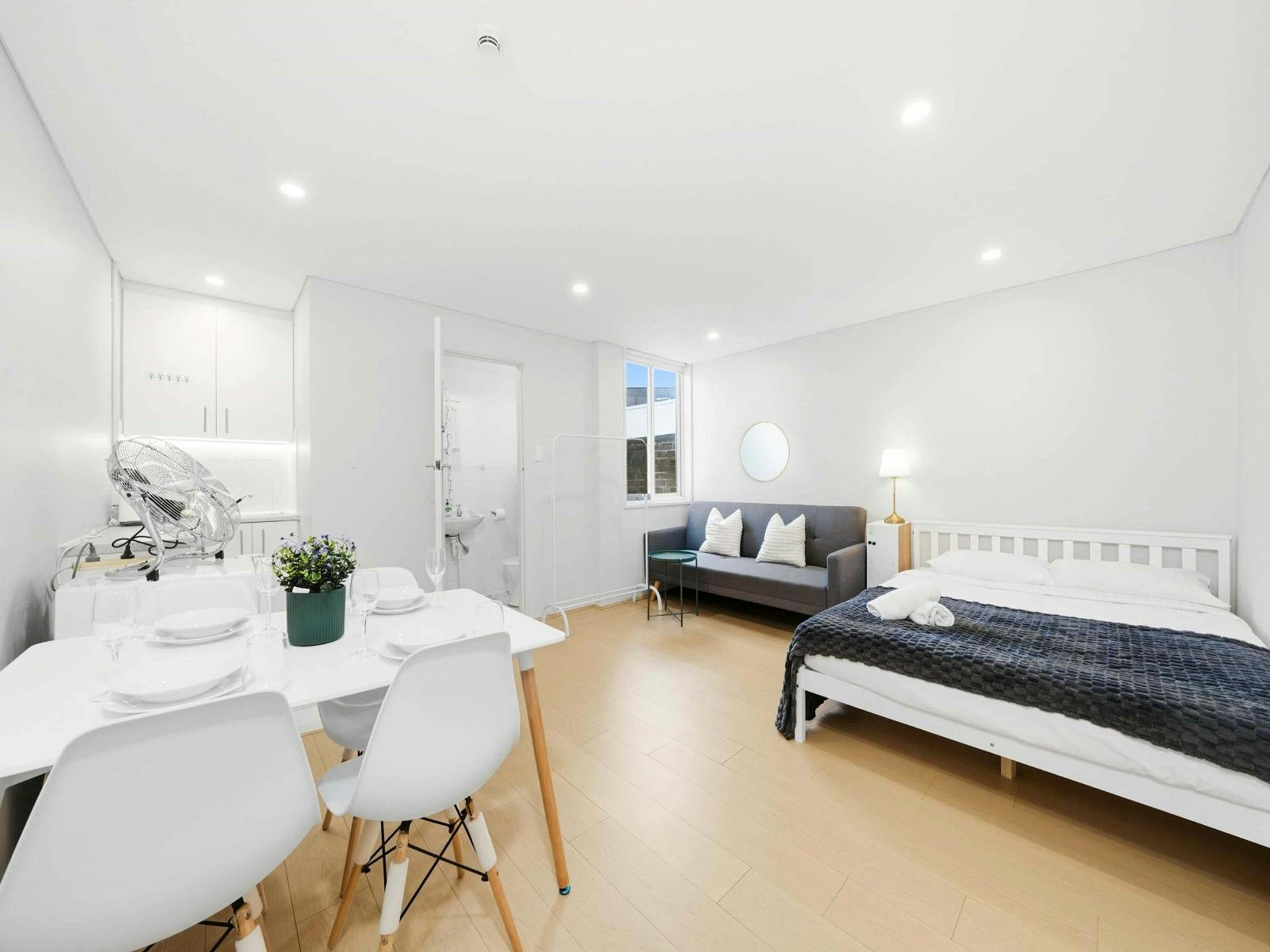 Bright and open studio layout featuring a comfortable double bed and dining area in a modern setting