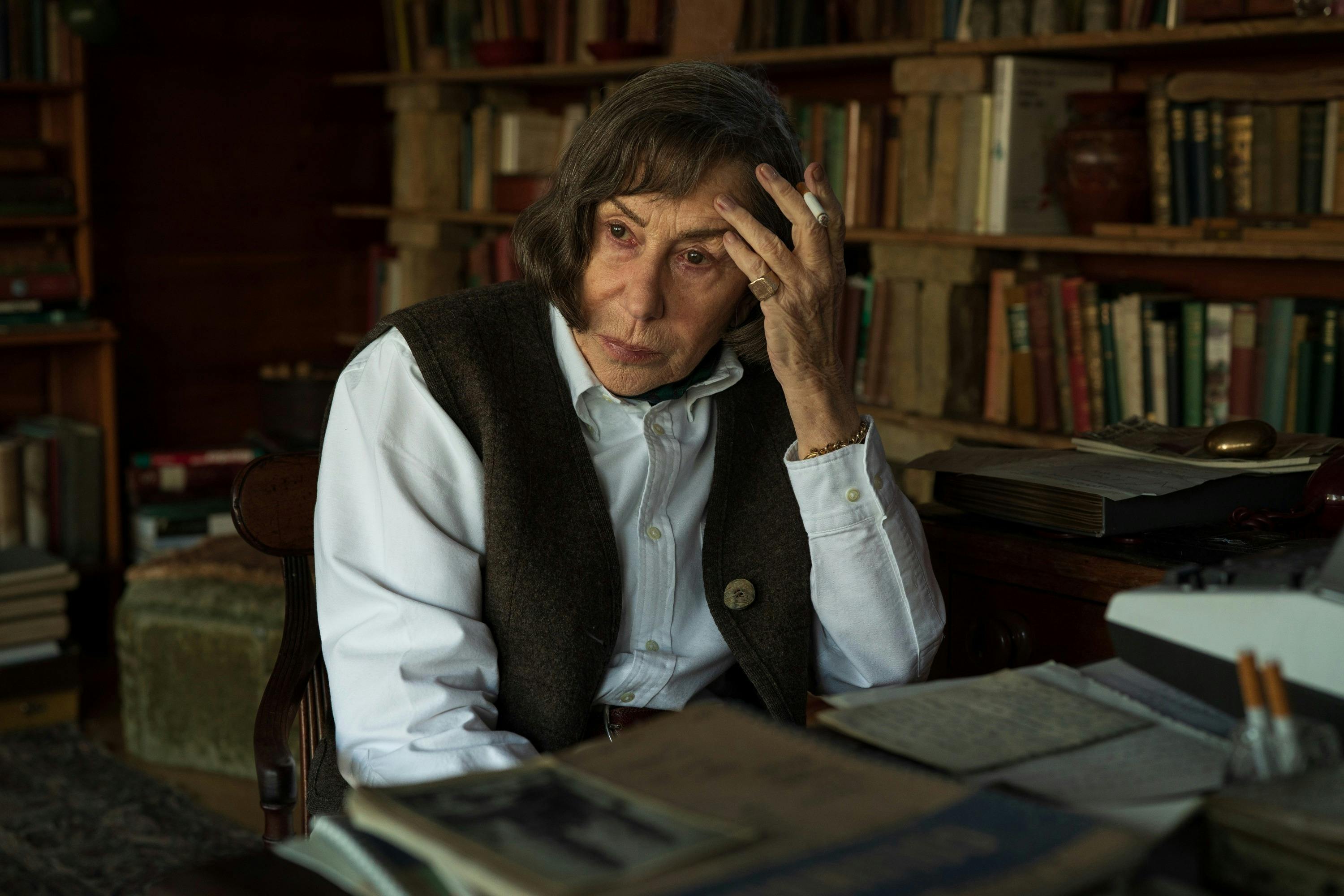 Woman sits at writing desk