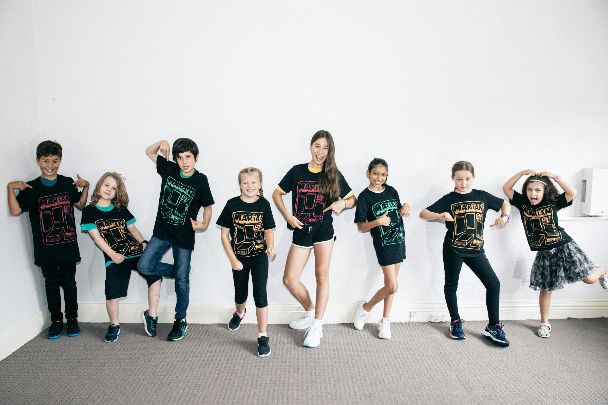 8 students in the age of 6-12 are doing different theatrical poses