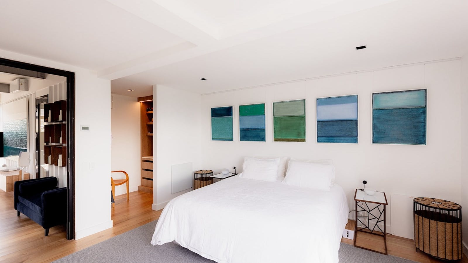 Serene master bedroom with king bed, large window, his/ her waredrobe, and art feature wall.