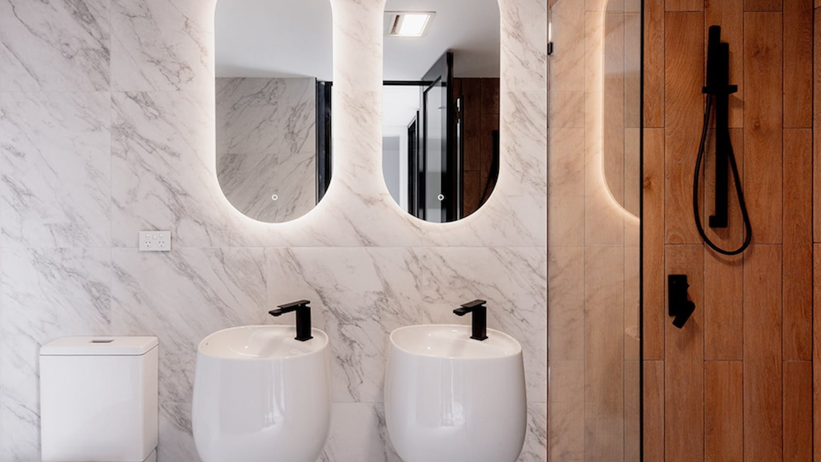 Elegant suite bathroom with twin basins, rain shower and high-end finishes