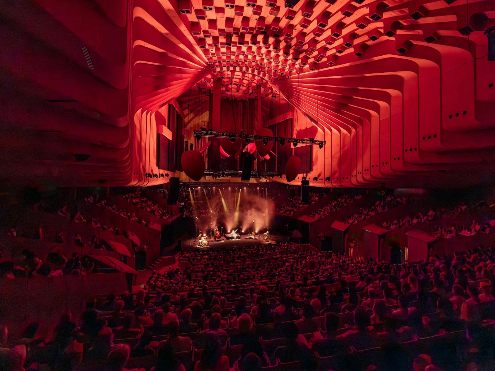 Interior of Sydney Opera House Concert Hall, full audience with dramatic red lighting