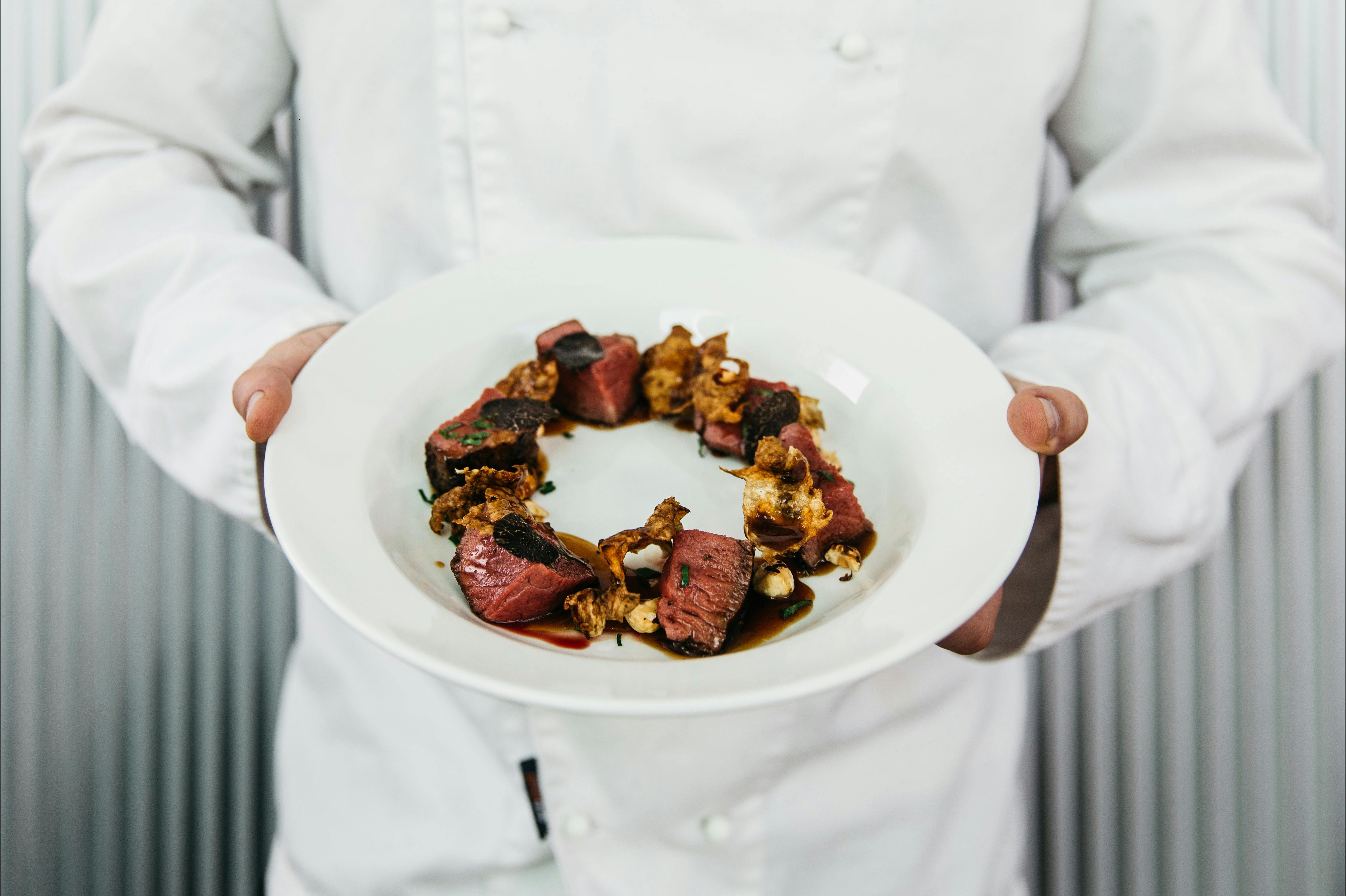 Chef holding a beautiful dish made with truffles