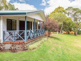 Bungalow with a deck on green grass at Blue Lake Holiday Park