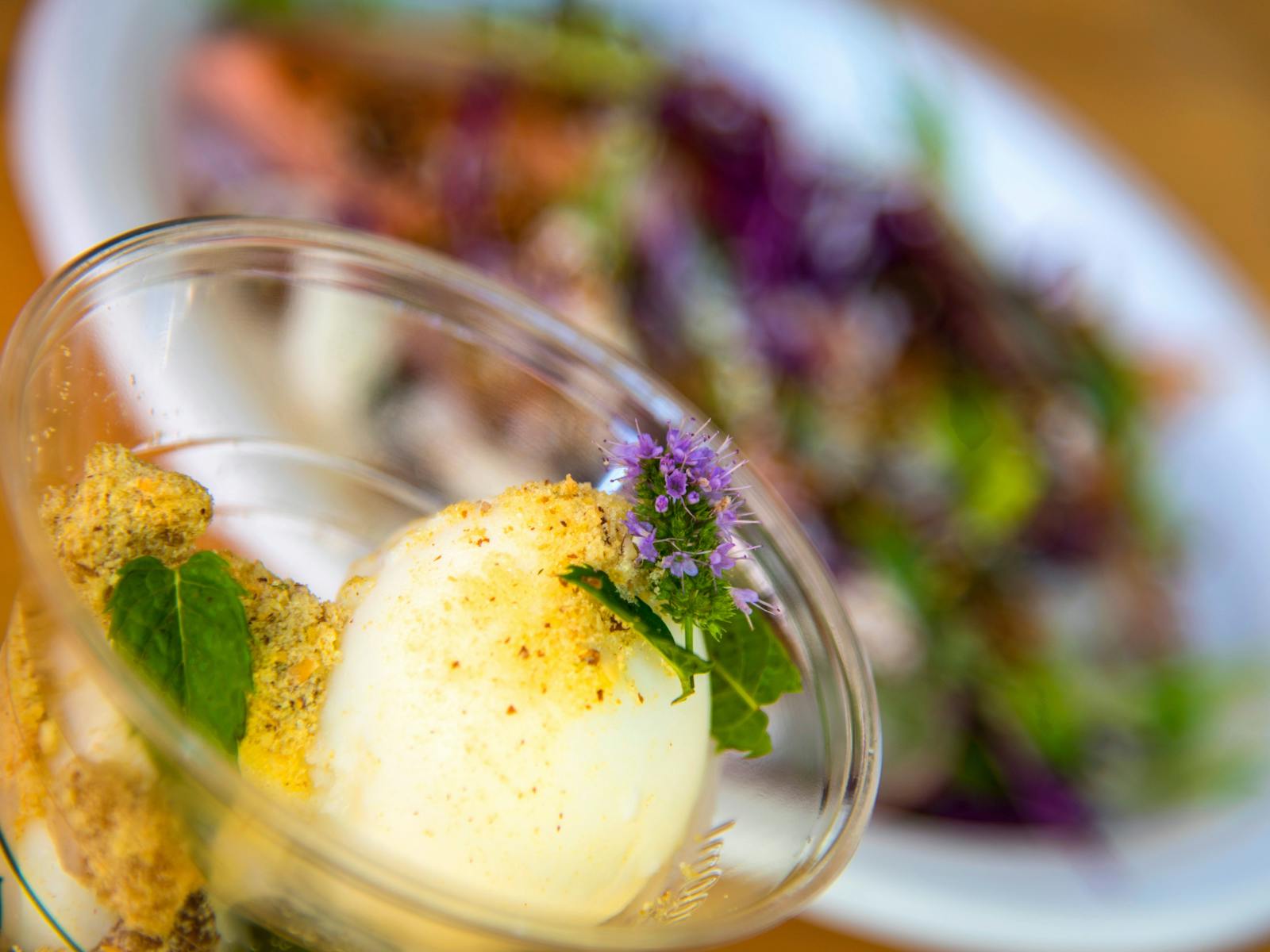 Dessert cup and food plate in background
